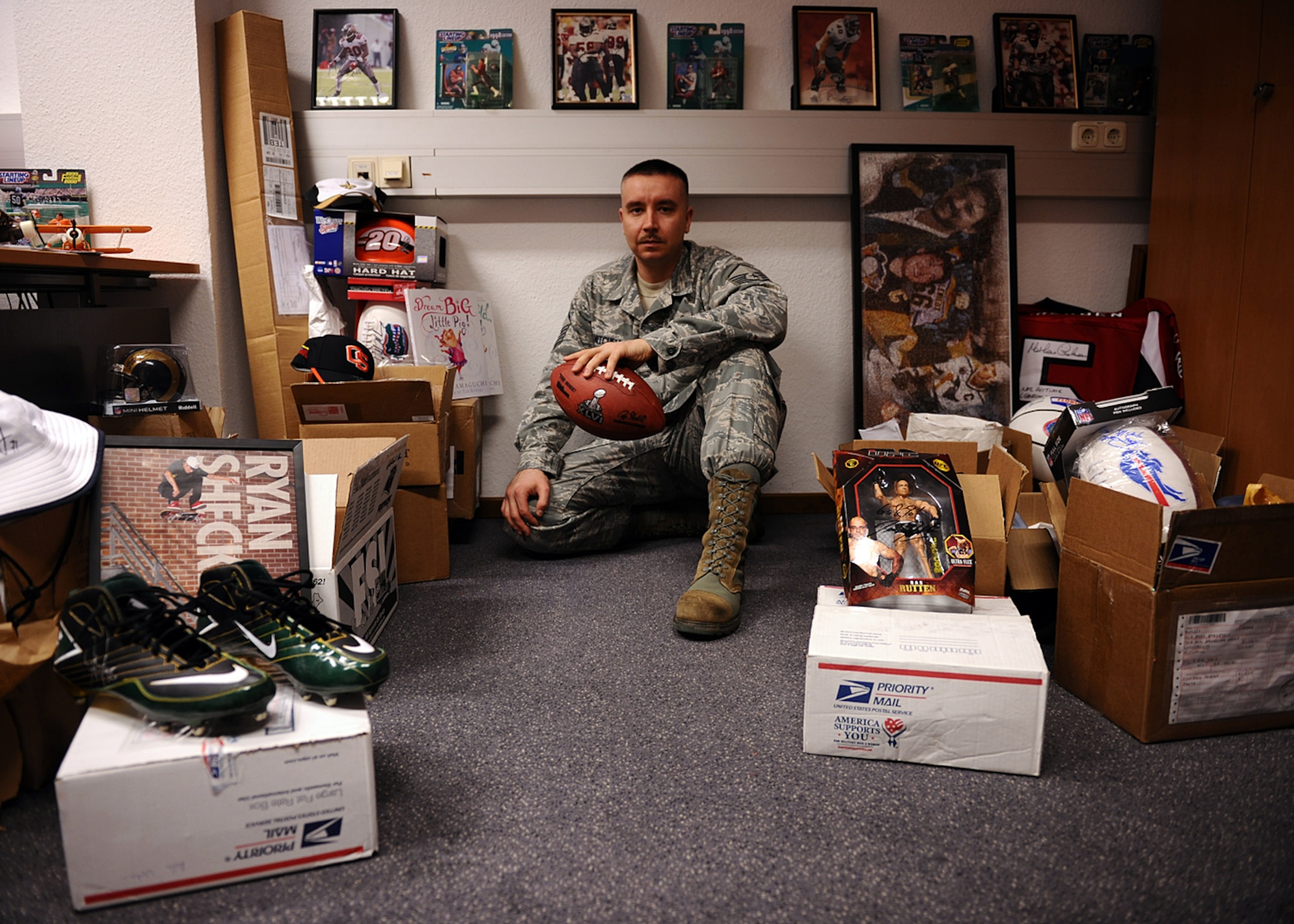 SPANGDAHLEM AIR BASE, Germany – U.S. Air Force Master Sgt. Anthony Mitchell, 52nd Logistics Readiness Squadron assistant first sergeant and Spangdahlem First Sergeant Council fundraising chairperson, sits among boxes of donated sports and TV memorabilia April 10, 2013. Mitchell began gather the memorabilia in January for a silent auction May 31 at the Brick House. The funds raised will go toward Operation Warm Heart, a program designed to help offset the needs of Airmen facing emergency-related financial hardships. (U.S. Air Force photo by Staff Sgt. Daryl Knee/Released)