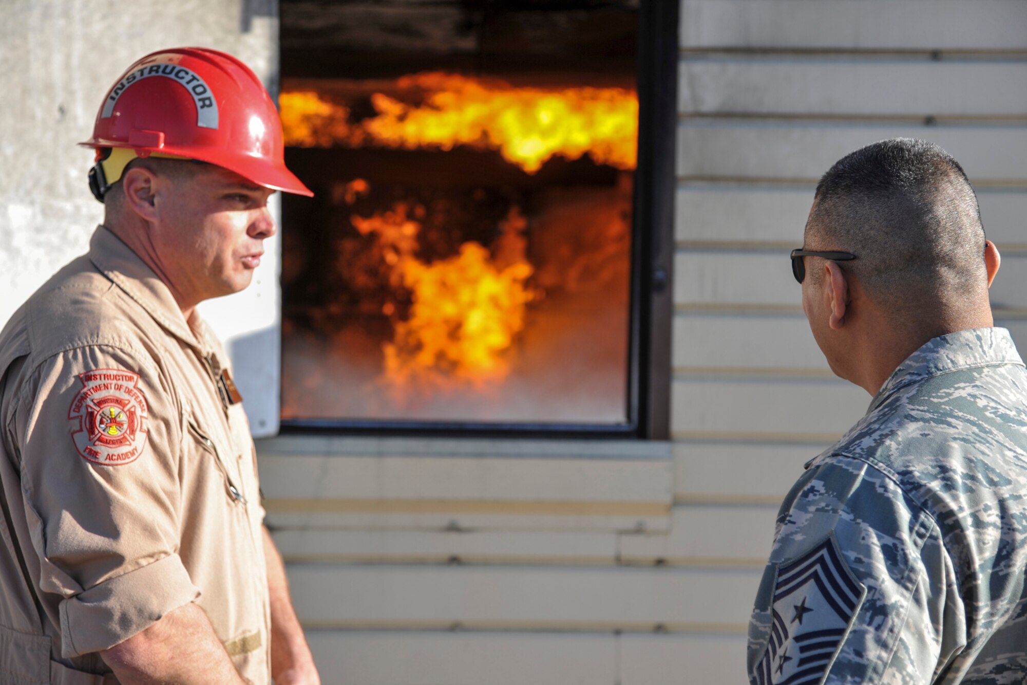 GOODFELLOW AIR FORCE BASE, Texas--Tech. Sgt. Frank Poyner, 312th Training Squadron instructor, demonstrates how the structural fire trainer operates to Chief Master Sgt. Gerardo Tapia, Command Chief of Air Education and Training Command, at the Louis F. Garland Defense Department Fire Academy, here, April 11. Tapia visited to get a first-hand look at the firefighting and intelligence, surveillance and reconnaissance mission on Goodfellow. (U.S. Air Force photo/ Airman 1st Class Michael Smith)