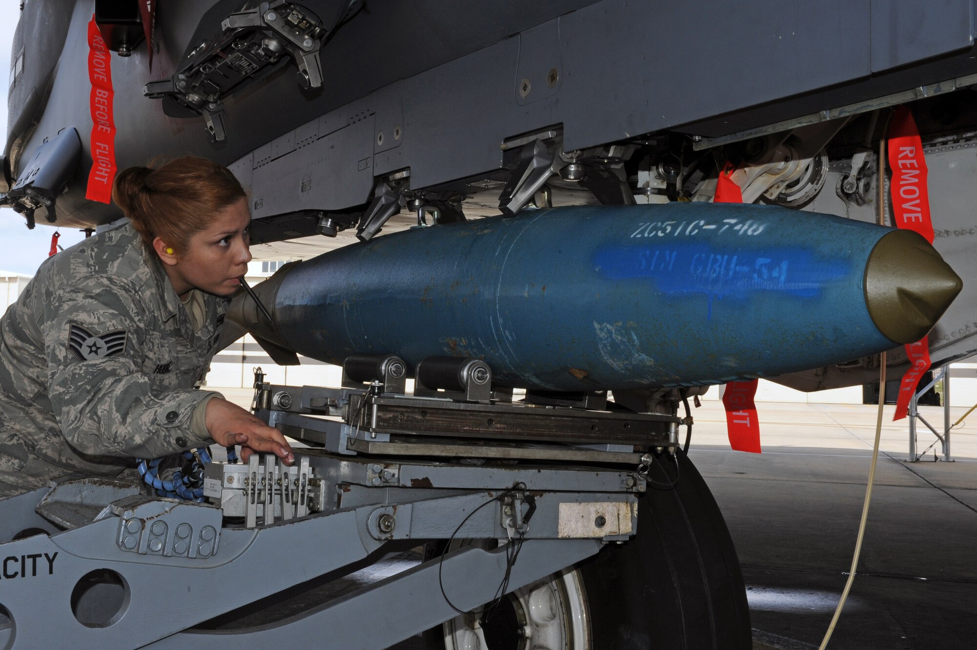 U.S. Air Force Staff Sgt. Lorena Hodge, 4th Aircraft Maintenance Squadron weapons load crew chief, aligns a BDU-50 munition for placement on an F-15E Strike Eagle during a load crew competition on Seymour Johnson Air Force Base, N.C., April 5, 2013. Four aircraft maintenance units raced against the clock to see which team could efficiently load the pre-designated munitions the quickest. (U.S. Air Force photo by Airman 1st Class John Nieves Camacho/Released)