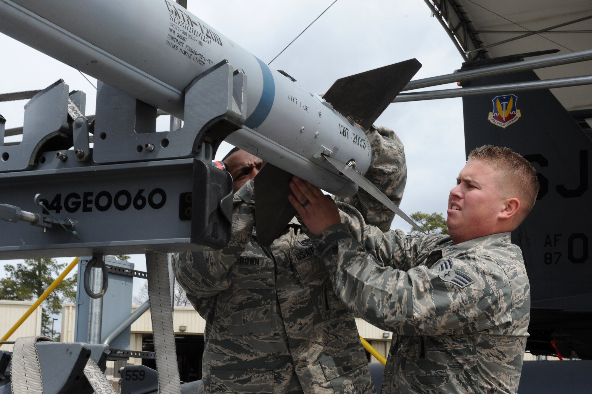 U.S. Air Force Staff Sgt. Steven Brown, 4th Aircraft Maintenance Squadron weapons load crew chief, and Senior Airman Kyle Vanderwagen, 4th AMXS weapons load crew member, install wings on an AIM-120 munition during a load crew competition on Seymour Johnson Air Force Base, N.C., April 5, 2013. Wings are installed on the AIM-120 munition for wartime configuration and flying assistance. (U.S. Air Force photo by Airman 1st Class John Nieves Camacho/Released)
