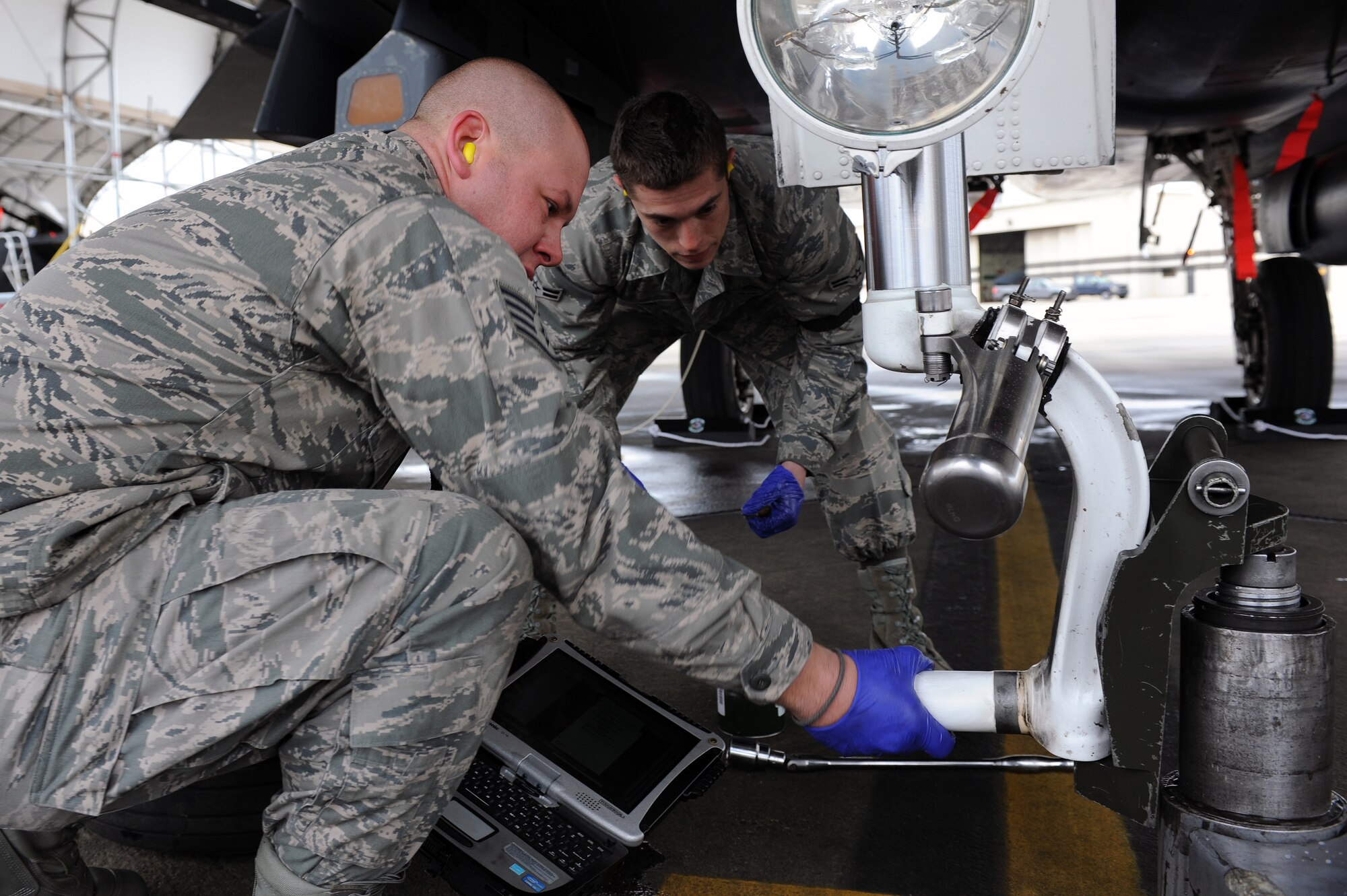U.S. Air Force Staff Sgt. Austin Kilgore and Airman 1st Class Timothy Ellison, 4th Aircraft Maintenance Squadron crew chiefs, inspect a strut on an F-15E Strike Eagle during a load crew competition on Seymour Johnson Air Force Base, N.C., April 5, 2013. During the competition, crew chiefs were evaluated on safety, efficiency and timeliness. (U.S. Air Force photo by Airman 1st Class John Nieves Camacho/Released)