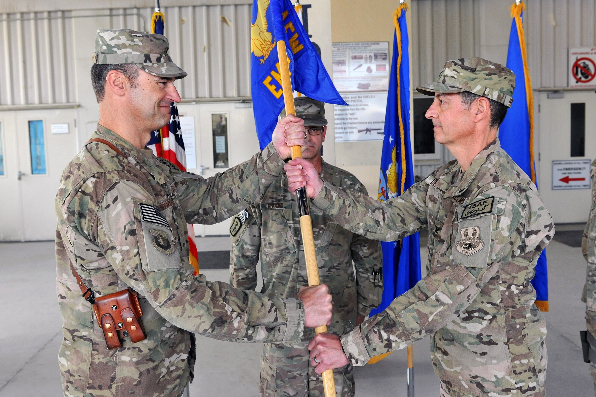 Brig. Gen. Joseph Guastella, 455th Air Expeditionary Wing commander, passes the 455th Expeditionary Medical Group guidon to Col. Dominic DeFrancis during a Change of Command ceremony on Bagram Airfield, Afghanistan, April 12, 2013.  DeFrancis will command Operation Enduing Freedom’s largest Role III medical care facility and the primary evacuation center and specialty referral hub in Afghanistan.  (U.S. Air Force photo/Senior Airman Chris Willis)