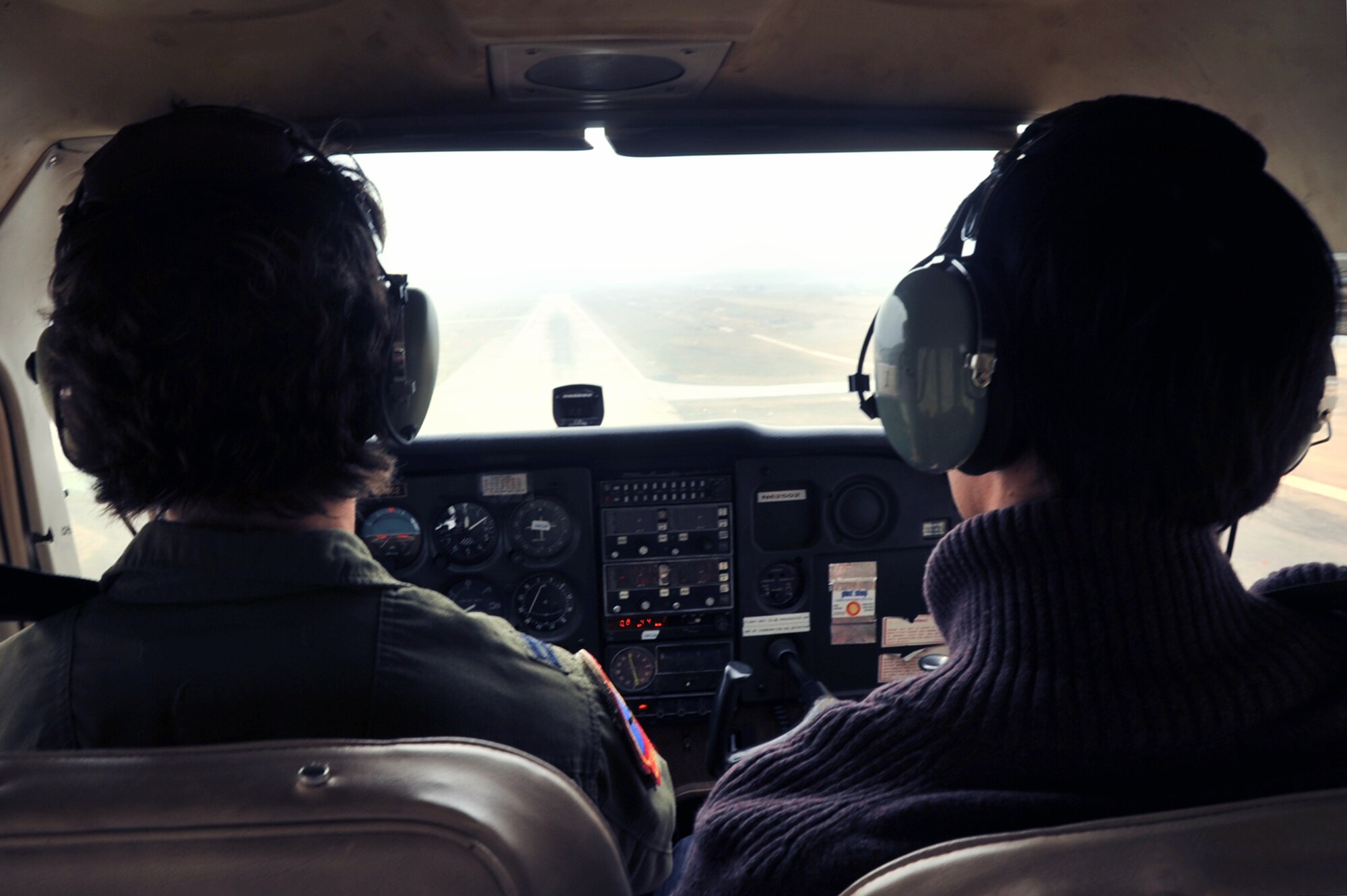 Capt. Mari Metzler, left, 51st Medical Group aerospace and operational physiologist flight commander, demonstrates landing a 1983 Cessna 172, while Yon San Yun, 51st Force Support Squadron Flight Training Center instructor pilot, grades her performance on the flightline at Osan Air Base, Republic of Korea, April 8, 2013. During her practice flight, Metzler performed three different landings. (U.S. Air Force photo/Senior Airman Alexis Siekert)