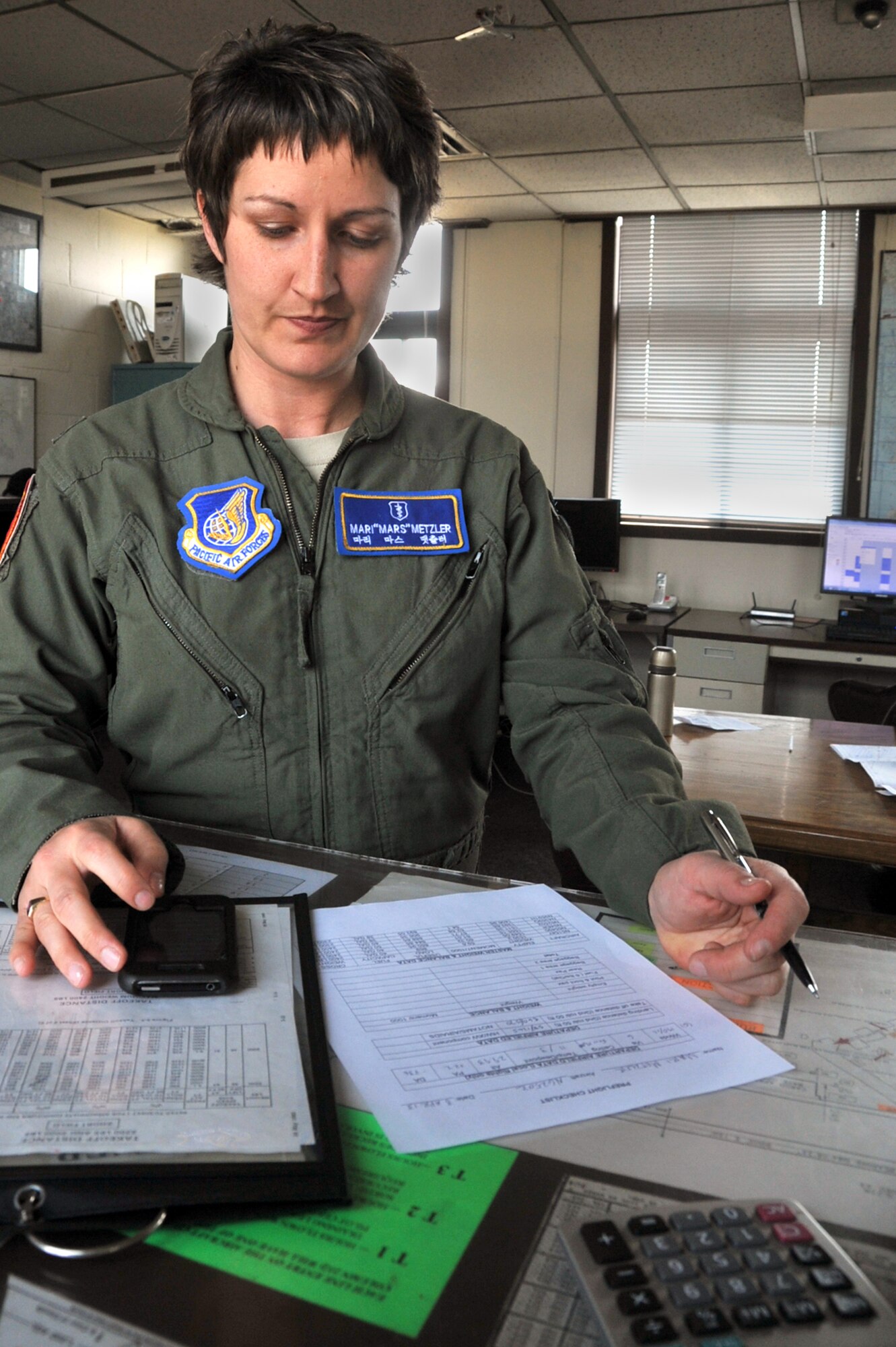 Capt. Mari Metzler, 51st Medical Group aerospace and operational physiologist flight commander, does her pre-flight paperwork before a local-area flight at the Osan Flight Training Center on Osan Air Base, Republic of Korea, April 8, 2013. During her flight in a 1983 Cessna 172, Metzler practiced various aerial maneuvers and different types of landings. (U.S. Air Force photo/Senior Airman Alexis Siekert)