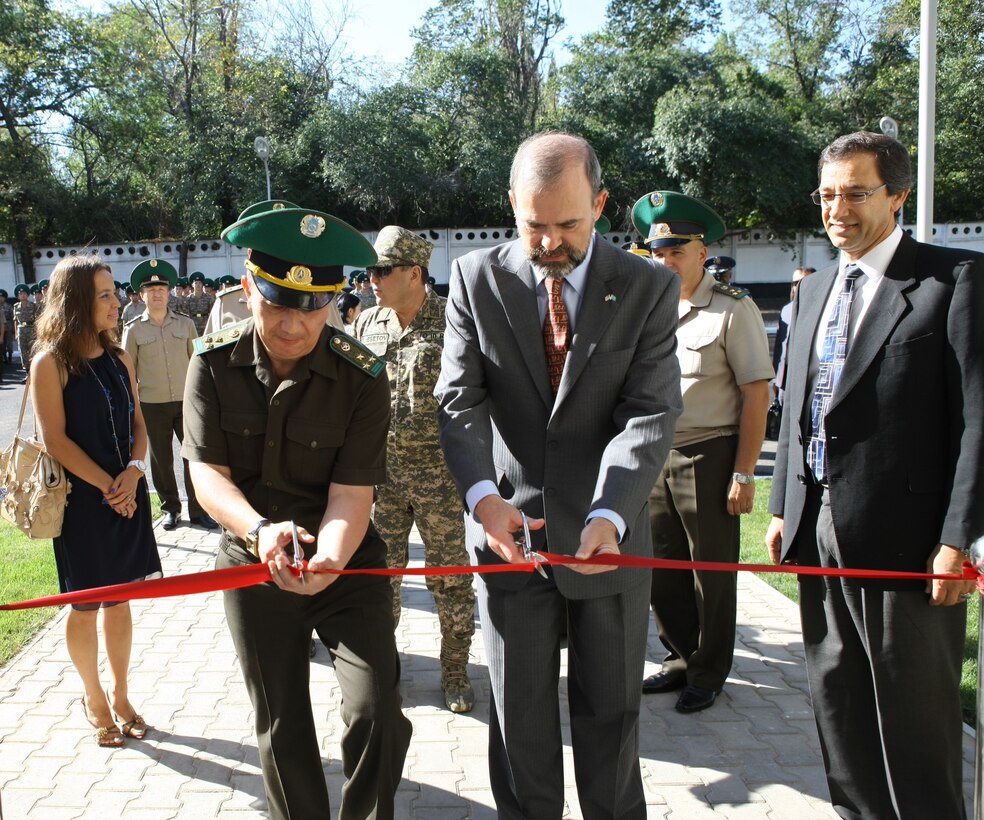 Acting Director of the Border Guard Service Col. Turganbek Stambekov and U.S. Ambassador Kenneth Fairfax cut the ribbon commemorating the opening of the regional canine training center at the Border Guard Academy in Almaty, Kazakhstan, Aug. 11. Far right, Khaled Masoud, USACE area engineer, looks on.