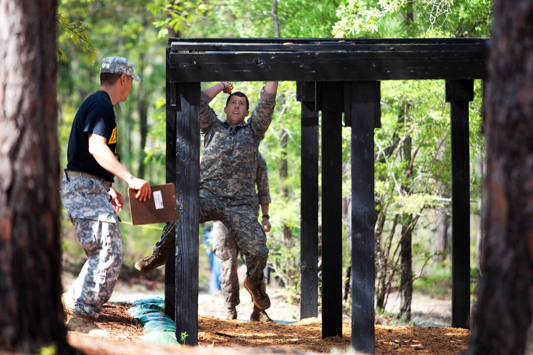 Army Staff Sgt. Christopher Peiffer, right, moves through the horizontal ladder obstacle during the 30th annual Best Ranger Competition on Fort Benning, Ga., April 12, 2013. Peiffer is assigned to the 75th Ranger Regiment.