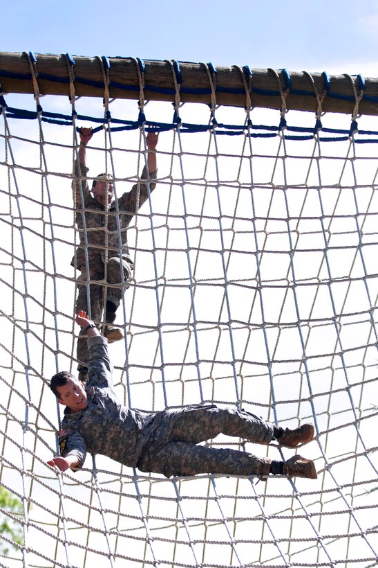 Army Staff Sgts. Christopher Peiffer, front, and Joe P. Slocum navigate the net obstacle during the 30th annual Best Ranger Competition on Fort Benning, Ga., April 12, 2013. Peiffer and Slocum are assigned to the 75th Ranger Regiment.