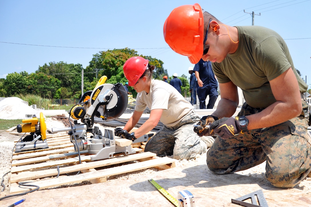 U.S. Marine Corps Lance Cpl. Joshua Rivera-Watson, right, and U.S. Air Force Staff Sgt. Jenna Rogers cut wood during construction at the Ladyville technical high school in Ladyville, Belize, April 10, 2013, during New Horizons 2013. Rivera-Watson, a combat engineer, is assigned to the Engineer Company, Marine Wing Support Squadron 472 and Rogers, a medical technician, is assigned to the 823rd Rapid Engineer Deployable Heavy Operational Repair Squadron Engineers. New Horizons is an annual series of joint humanitarian assistance exercises, sponsored by U.S. Southern Command, which deploys U.S. military engineers, veterinarians, medics and other professions to Central and South American nations for medical, training and construction projects.