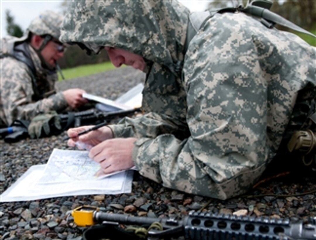 U.S. Army soldiers plot eight-digit grid coordinates on a map before participating in a daytime land navigation course while competing for the Expert Field Medical Badge at Joint Base Lewis-McChord, Wash., on April 10, 2013.  The badge is awarded to soldiers in medical professions who pass a variety of tests designed to measure proficiency in medical procedures, tactical skills and physical conditioning.   
