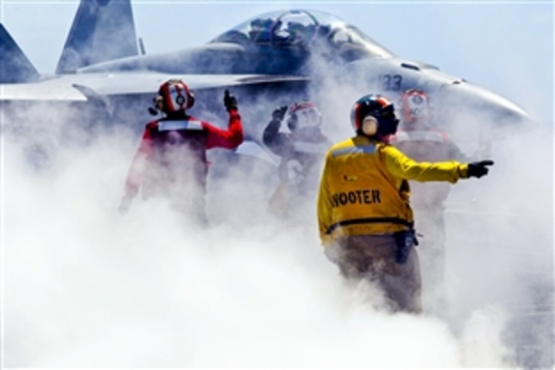 U.S. Navy Lt. Mary Gresko, front, directs an F/A-18F Super Hornet assigned to Strike Fighter Squadron 154 before a launch from the aircraft carrier USS Nimitz in the Pacific Ocean, April 9, 2013. The Nimitz and Carrier Air Wing 11 are underway for a training exercise to prepare for an upcoming deployment.