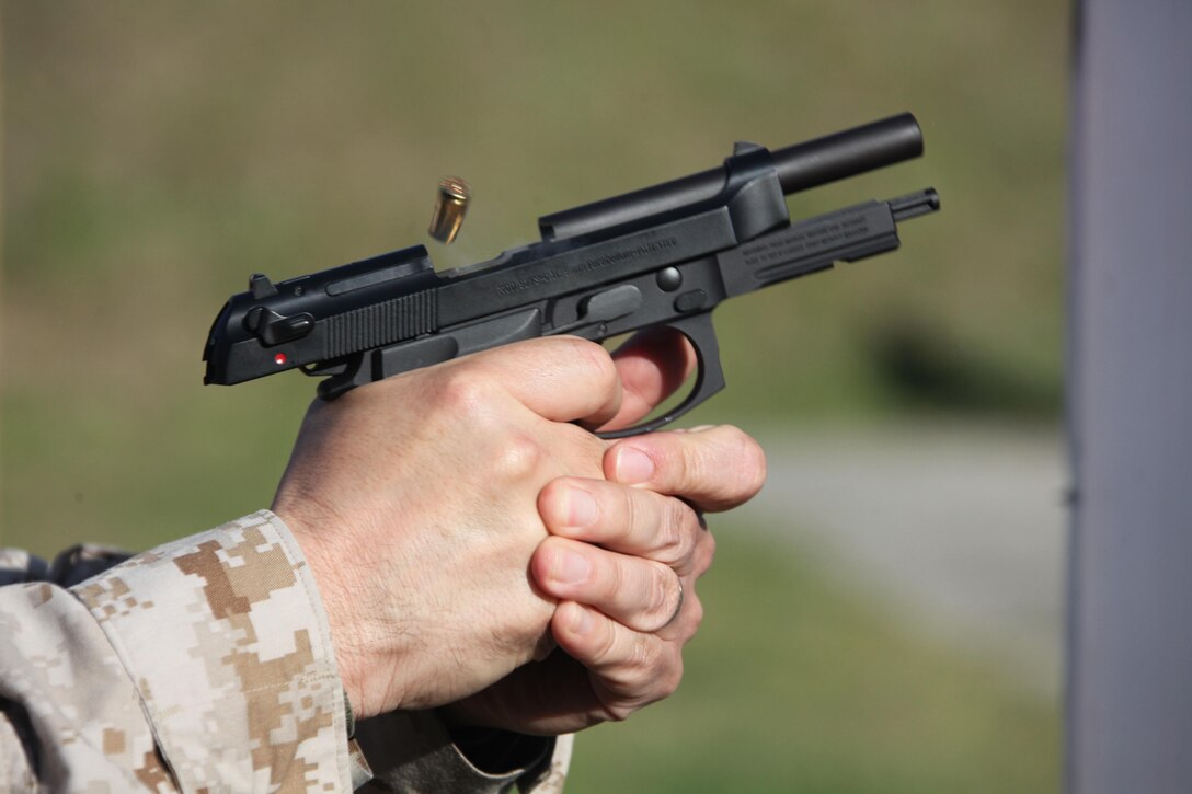 A 9mm casing is ejected out of a M9 Berretta during a Provost Marshall Office pistol shoot at the station range April 11. “This training helps them learn how to not only utilize correct use of cover, but also gives them confidence while using two of our primary weapons we have in our arsenal as officers,” said Master Gunnery Sgt. John P. Wade, the Provost Sergeant with PMO. 