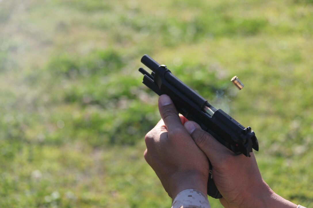 A 9mm casing is ejected out of a M9 Berretta during a Provost Marshall Office pistol shoot at the station range April 11. “This training helps them learn how to not only utilize correct use of cover, but also gives them confidence while using two of our primary weapons we have in our arsenal as officers,” said Master Gunnery Sgt. John P. Wade, the Provost Sergeant with PMO. 