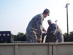 Texas Army National Guard Sgt. John Stubbs, left, and Sgt. Daniel McMurray load equipment onto trucks Tuesday morning in Bryan, Texas, while preparing for Tropical Storm Dolly which was predicted to strengthen to hurricane force. At least 600 Texas National Guardmembers responded to a call Monday by Gov. Rick Perry to prepare for the storm.