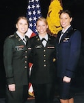 Army Chief Warrant Officer Amber Smith (left) and Air Force Capt. Kelly Smith (right) celebrate at a graduation for their younger sister, Army Chief Warrant Officer Lacey Smith (center). All three Smith sisters are pilots in the armed forces.