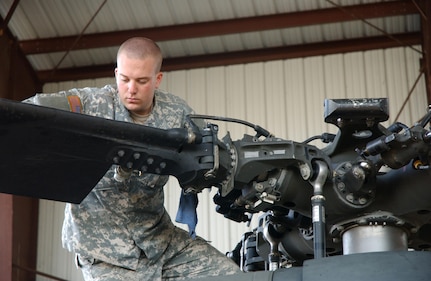 Army Private Bret Williams, a UH-60 Black Hawk mechanic assigned to Task Force Mather, part of Joint Task Force Sentinel, inspects a Black Hawk rotor.