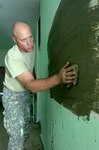Sgt. Steven Allen of the 155th Engineer Company of the South Dakota Army National Guard seals the old distribution window inside De Nieuwe Grond Clinic July 28 in Wanica, Suriname.