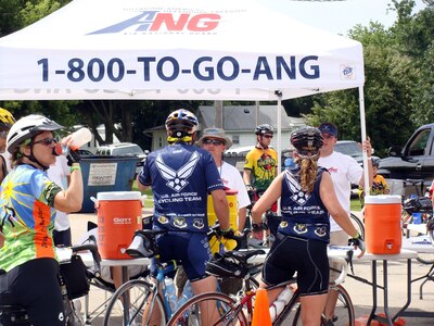 Members of the U.S. Air Force cycling team chat with Chief Master Sgt. Timothy Whisler (left) and Tech. Sgt. Spencer C. Sweeney (right), both firefighters from the Iowa Air National Guard's 132nd Fighter Wing. "Team H2O" manned at the water station in Montour, Iowa during this year's Register's Annual Great Bike Ride Across Iowa. This year marks the 14th year that the Iowa Air Guard has provided water for the event.