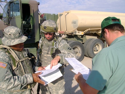 Sgt. Noel Watson and Sgt. Dennis Palmer of the 1067th Transportation Company of the Pennsylvania Army National Guard, review final details of a convoy briefing with a Northrup Grumman contractor prior to a Combat Logistics Patrol at the National Training Center in Fort Irwin, Calif. The unit, which is based in Phoenixville and Lehighton, Pa., drove 2,580 miles to Fort Irwin for their three-week annual training.