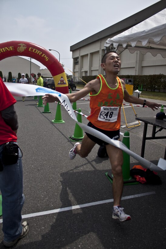 Yoichi Kohno, first place male finisher of the 46th annual Kintai Marathon, crosses the finish
line in front of the IronWorks Gym here, April 14, 2013. The event included a full marathon, half marathon, and five-kilometer walk.