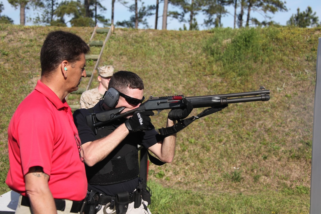 Officer Victor L. Moore, a civilian police officer with the Provost Marshall Office, fires a slug out of a Benelli M4 Super 90 Shotgun during a PMO Shotgun shoot at the station range April 11. The shooters started on the pistol firing 18 shots during the evaluation while maneuvering from a standing position down to lying down and seeking cover. They then fired more than 25 shots from the shotgun while conducting a similar course of fire.