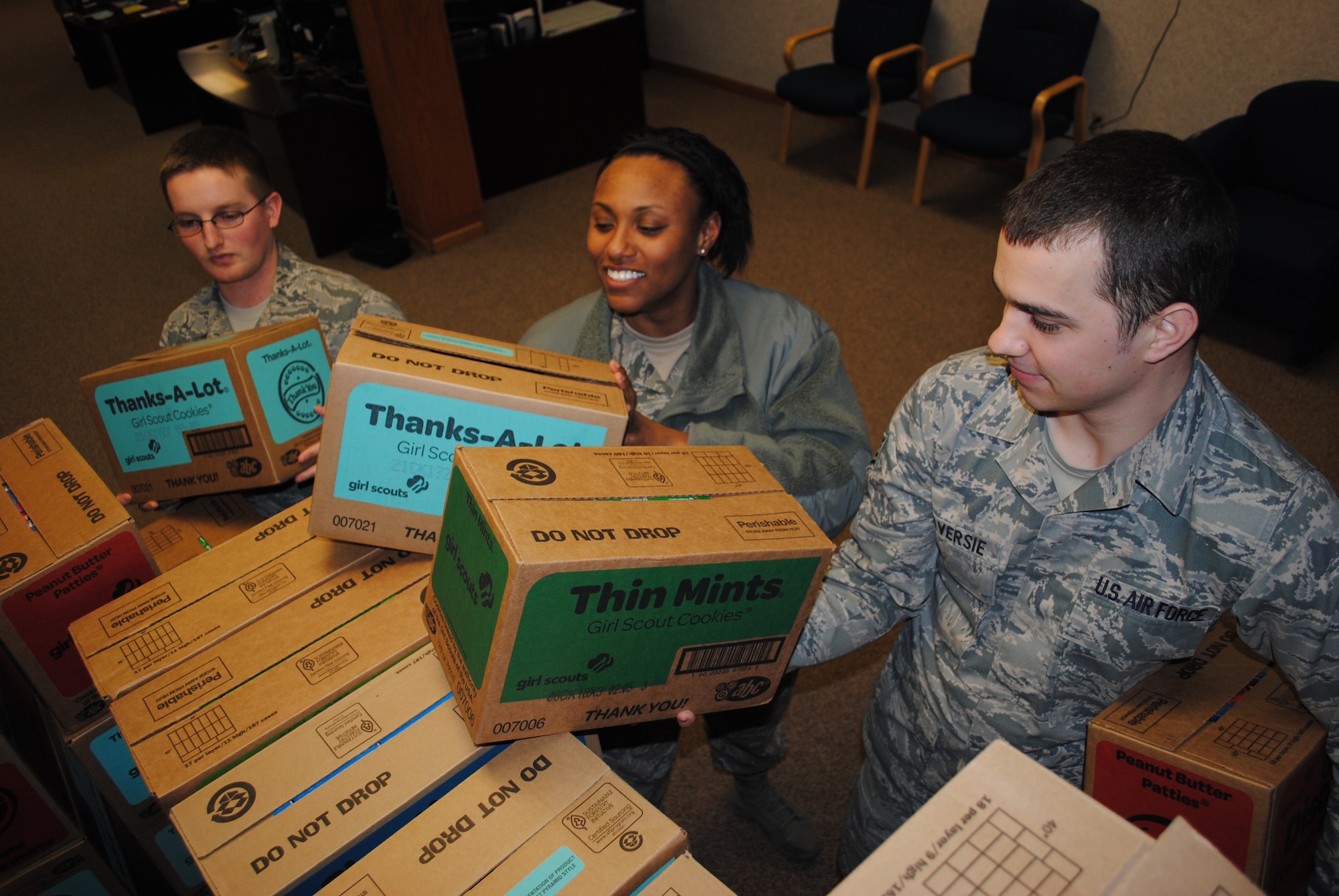 (From left) Senior Airman Zach Adams, Staff Sgt. Sonoma McNair and Staff Sgt. Zach Traversie, from the 69th Maintenance Squadron, help carry boxes of Girl Scout cookies back to their work stations to share with their fellow Airmen and coworkers on April 16, 2013.  The Girl Scouts showed their appreciation for service members at Grand Forks Air Force Base, N.D., by donating more than 34,000 boxes of cookies. (U.S. Air Force photo/Staff Sgt. Luis Loza Gutierrez)
