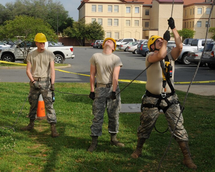 Airmen from 2 CS cable antenna maintenance hold a safety line during tower maintenance on Barksdale Air Force Base, La., April 17, 2013. Airmen from 2 CS cable antenna maintenance are responsible for maintaining all physical and fiber optic structures. There is a total of 90,000 miles of cable on the base. (U.S. Air Force photo/Senior Airman Sean Martin)