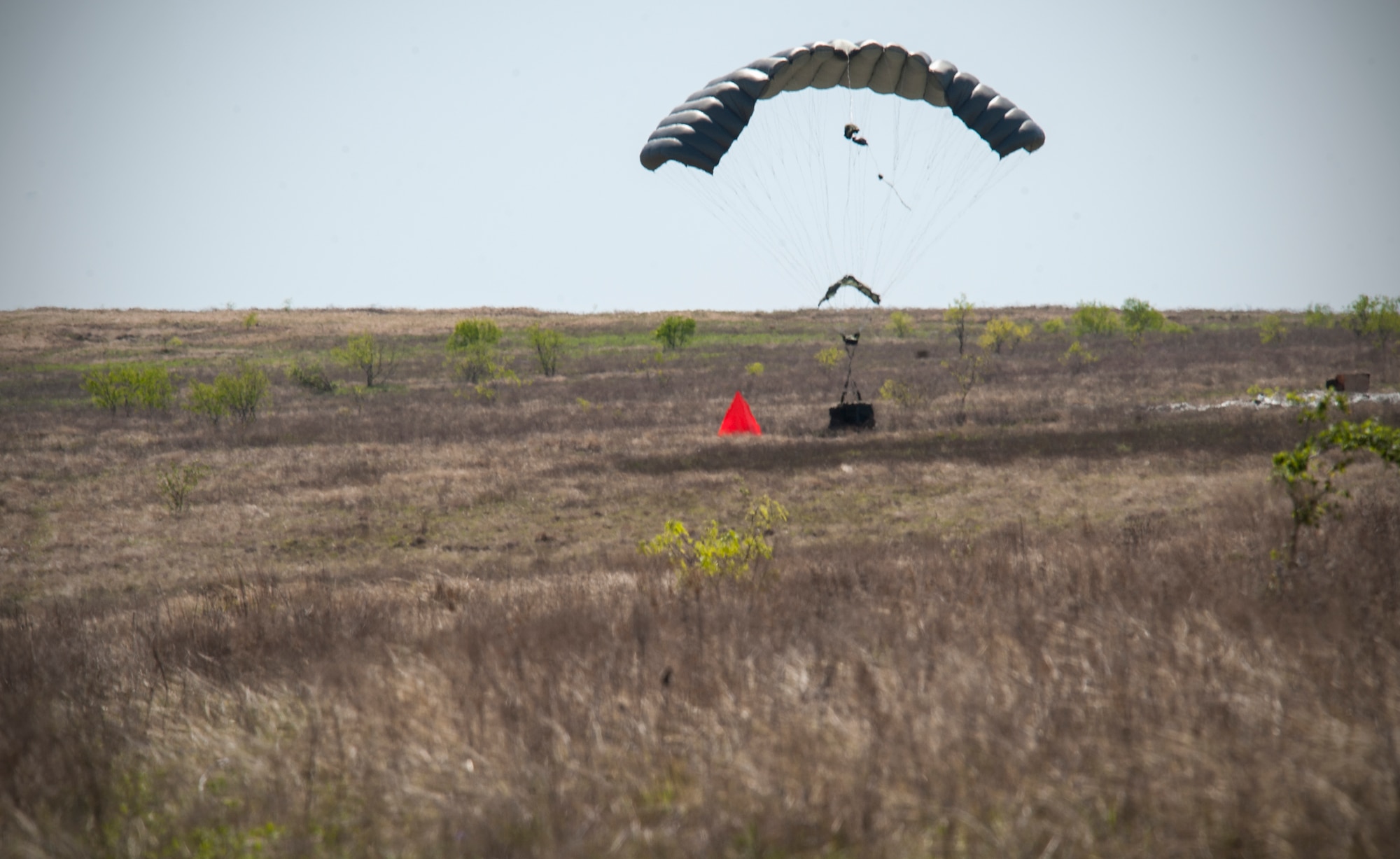A Joint Precision Airdrop System (JPADS) bundle lands at its designated target during the first Big Country JPADS Capabilities Training Exercise April 11, 2013, at Fort Hood, Texas. Traditional airdrops by Air Force airlifters are at altitudes of 400-1,000 feet. With JPADS, those same bundles can be dropped and guided from altitudes as high as 25,000 feet with pinpoint accuracy allowing the aircraft to safely avoid enemy ground fire. (U.S. Air Force photo by Airman 1st Class Jonathan Stefanko/Released)