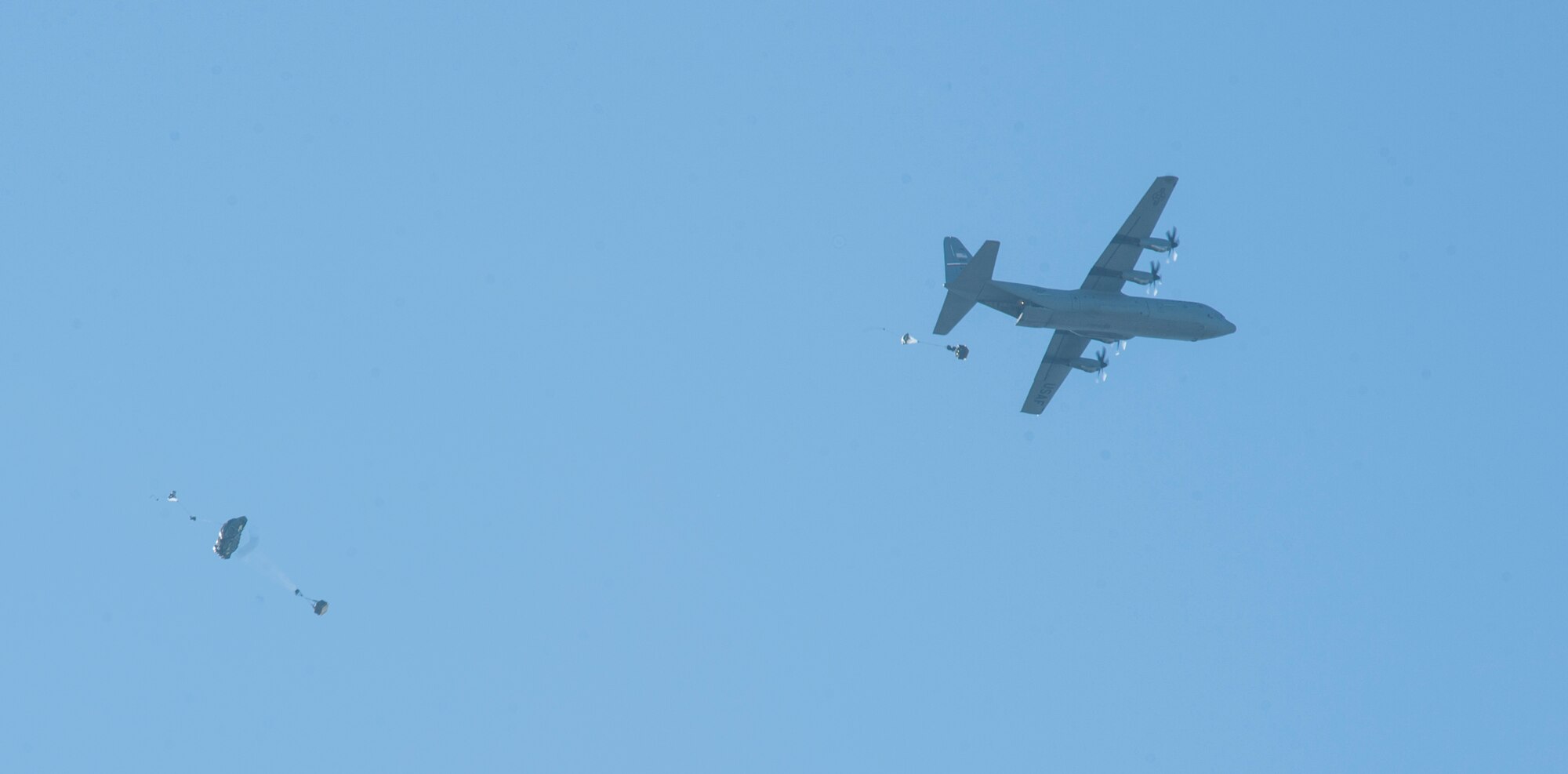 A C-130J from the 317th Airlift Group, Dyess AFB, Texas, drops two Joint Precision Airdrop System (JPADS) bundles during the first Big Country JPADS Capabilities Training Exercise April 11, 2013, at Fort Hood, Texas. During the exercise, 25 JPADS bundles were dropped by C-130Js from Dyess AFB and Keesler AFB, Miss., C-17s from Joint Base Charleston, S.C., and Joint Base Lewis-McChord, Wash., as well as an MC-130J from Cannon AFB, N.M., to demonstrate the ability of the airlift community to drop cargo with pinpoint accuracy to designated drop zones. (U.S. Air Force photo by Airman 1st Class Jonathan Stefanko/Released)
