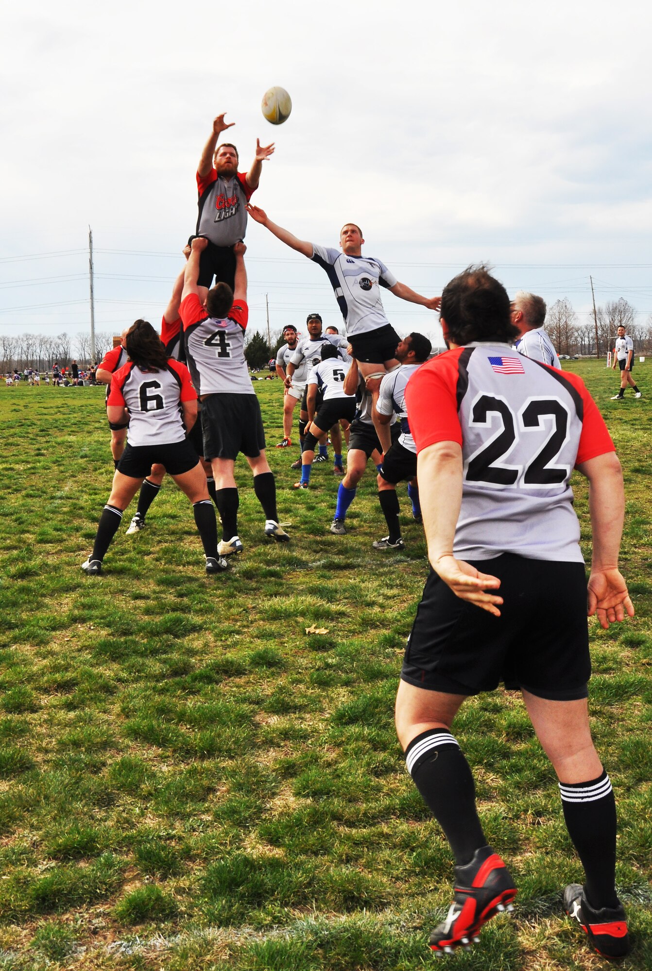 A Belleville Rowdy team member throws a ball to his teammate in hopes that he will jump high enough to catch it and then score points for his team April 6, 2013.  Rugby is a style of football that is prominently seen in England.  A rugby match consists of two halves of 40 minutes each.  The object of the game is to score the greatest number of points. (U.S. Air Force photo/Airman Megan Friedl)