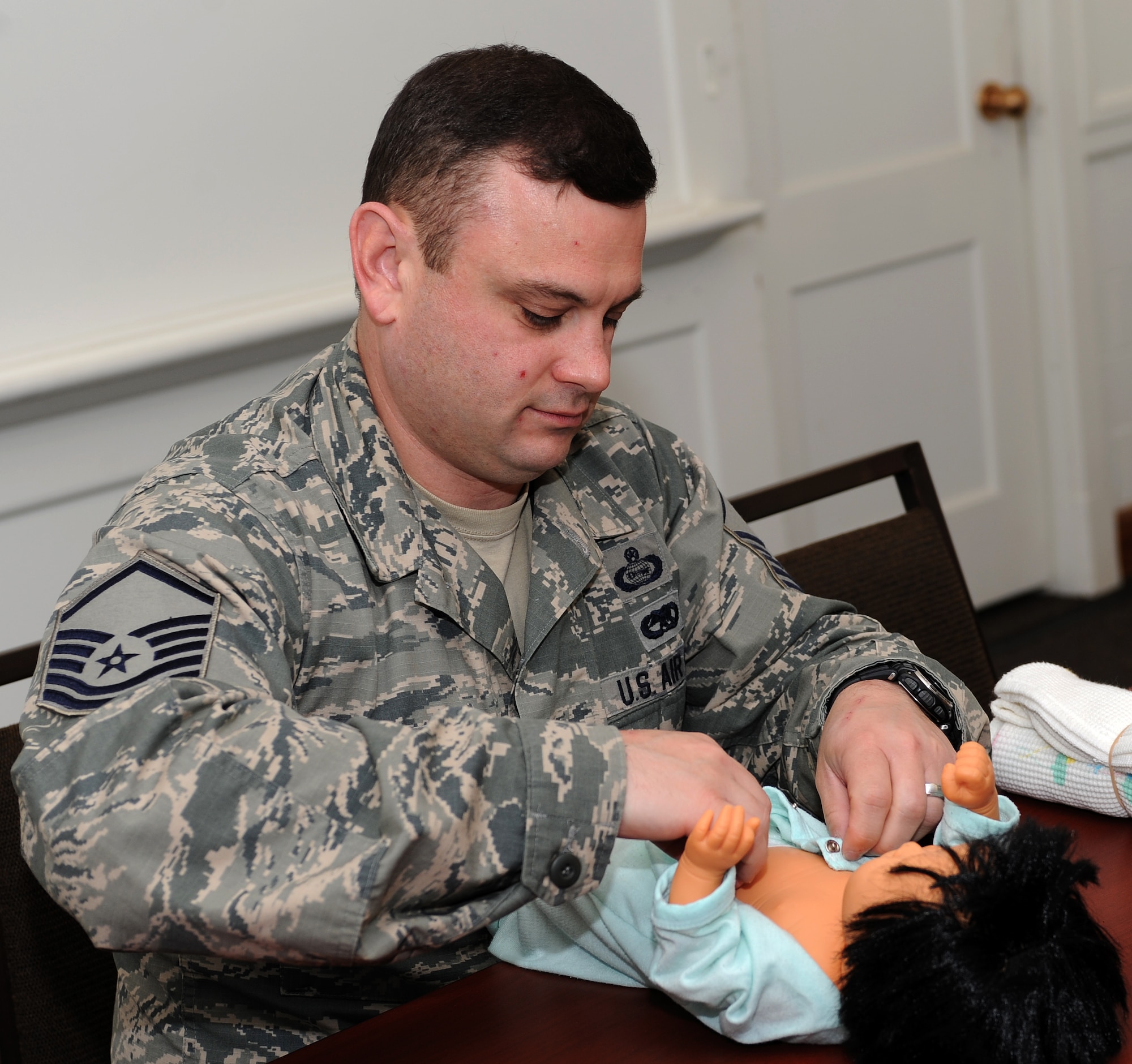 U.S. Air Force Master Sgt. Byron Rauch, father of three and currently expecting his fourth daughter, dresses a practice doll during a New Fathers Workshop at Langley Air Force Base, Va. April 11, 2013. First-time and experienced fathers came together to share experiences and tips on what to expect during a spouse’s pregnancy and the first year of a child’s life. (U.S. Air Force photo by Senior Airman Teresa Aber/Released)