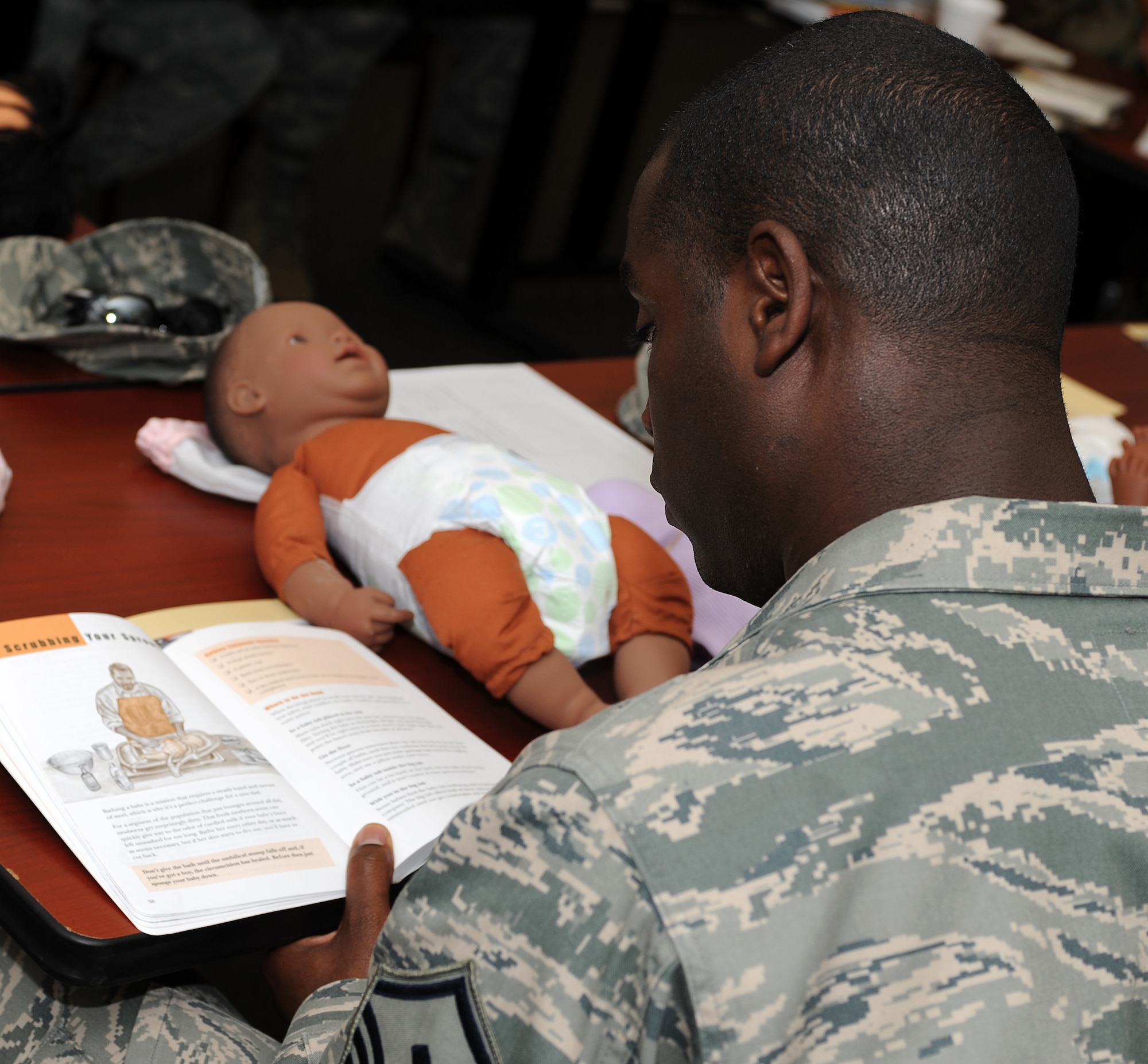U.S. Air Force Master Sgt. Ralph Oliver, 45th Intelligence Squadron first sergeant, reads tips on bathing a newborn child during a New Fathers Workshop at Langley Air Force Base, Va. April 11, 2013. Oliver is expecting his first child in the coming months. (U.S. Air Force photo by Senior Airman Teresa Aber/Released)
