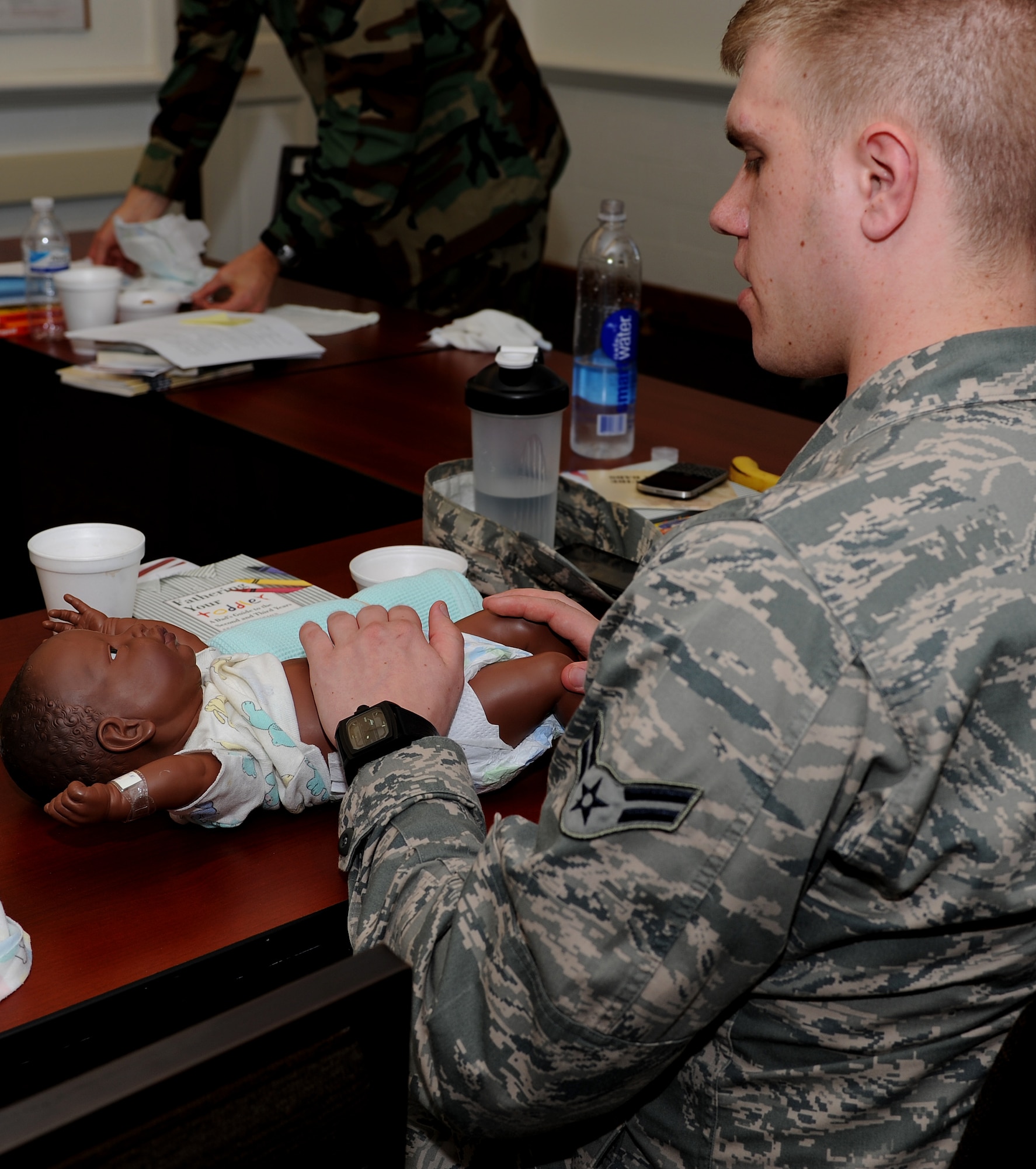 U.S. Air Force Airman 1st Class Joshua Larson, who is expecting his second child, puts a diaper on a practice doll during a New Fathers Workshop at Langley Air Force Base, Va., April 11, 2013. The workshop was hosted by the 633rd Medical Operations Squadron Family Advocacy Outreach Program. (U.S. Air Force photo by Senior Airman Teresa Aber/Released)