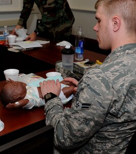 U.S. Air Force Airman 1st Class Joshua Larson, who is expecting his second child, puts a diaper on a practice doll during a New Fathers Workshop at Langley Air Force Base, Va., April 11, 2013. The workshop was hosted by the 633rd Medical Operations Squadron Family Advocacy Outreach Program. (U.S. Air Force photo by Senior Airman Teresa Aber/Released)