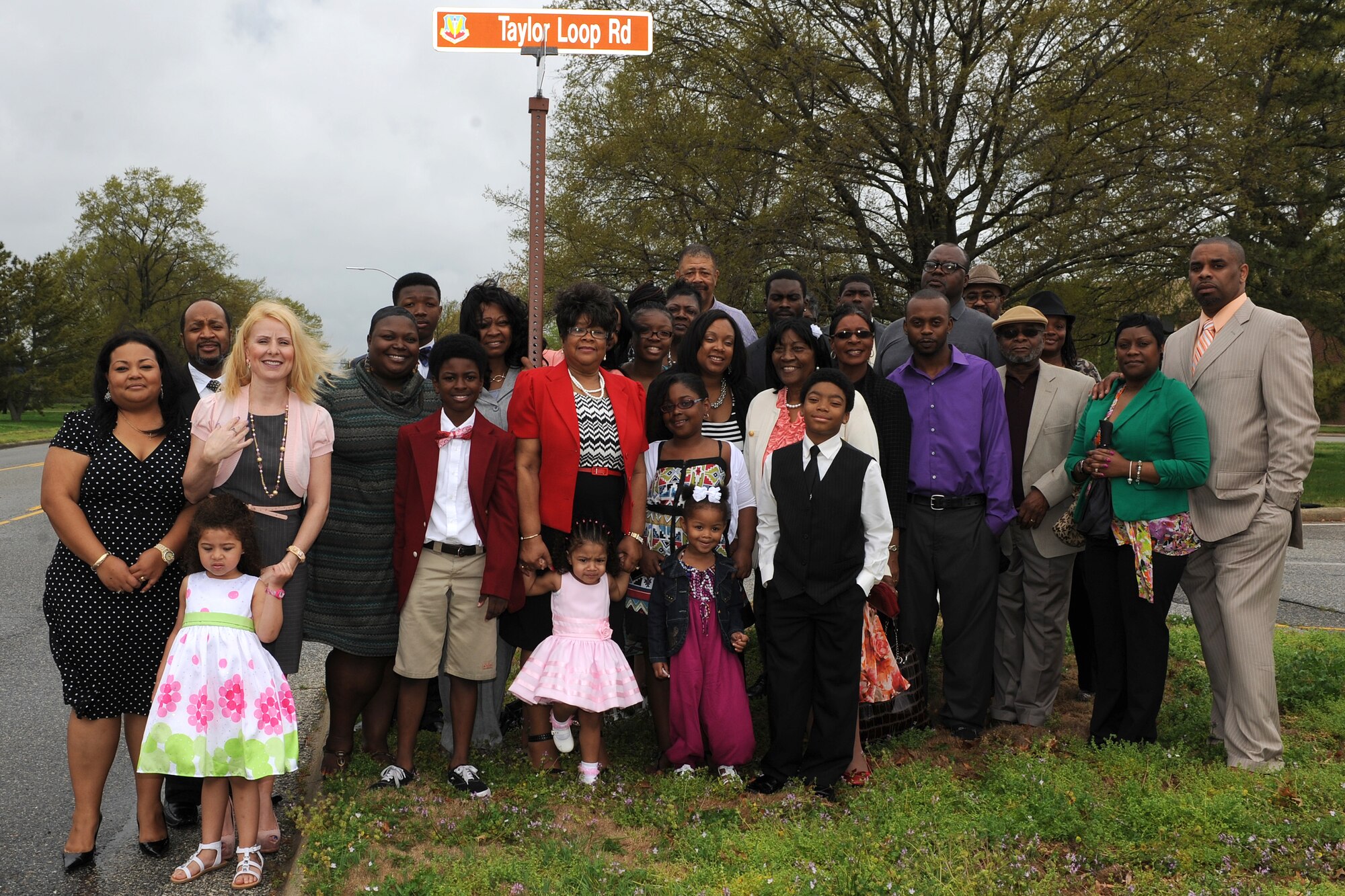 The late U.S. Air Force Senior Master Sgt. Ernest Taylor’s family and friends gather near Taylor Loop Road, which wraps around the Military Personnel Flight building and faces Langley’s dorm buildings, during a dedication ceremony for Taylor Loop Road, at Langley Air Force Base Va., April 12, 2013. The street was named after Senior Master Sgt. Ernest Taylor and the legacy of caring for his Airmen that he left behind. (U.S. Air Force photo by Senior Airman Teresa Aber/Released)