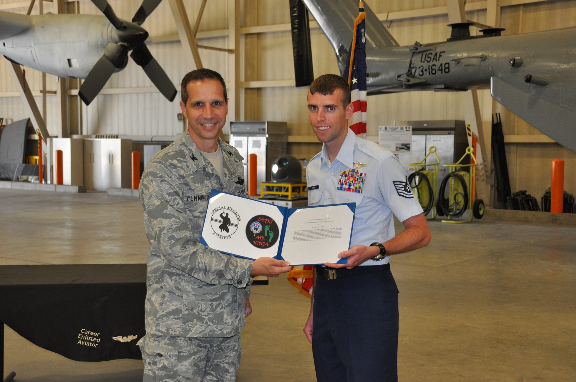 Col. Jeffrey T. Pennington, 433rd Airlift Wing Commander, Joint Base San Antonio-Lackland, presents Tech Sgt. Michael Senigo, 733rd Training Squadron, with a certificate during a gathering to congratulate him on being nominated as AFRC’s choice for enlisted Aircrew Member of the Year Award.