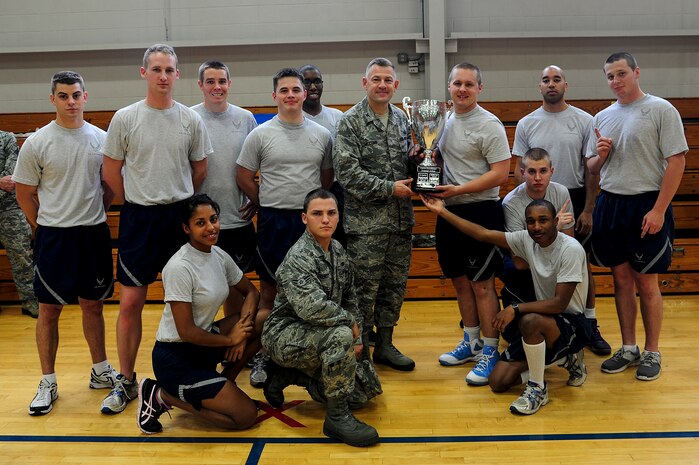 Col. Richard McComb, Joint Base Charleston commander, gathers with Airmen, from Dorm 473 and the Dorm Challenge trophy April 12, 2013, at the Fitness Center at Joint Base Charleston - Air Base, S.C. The quarterly Dorm Competition is a Wing initiative intended to encourage and incorporate all aspects of Comprehensive Airman Fitness, while encouraging resident interaction and camaraderie. The Dorm Challenge consisted of push-ups, sit-ups, cornhole and a game of dodgeball. (U.S. Air Force photo/Staff Sgt. Rasheen Douglas)