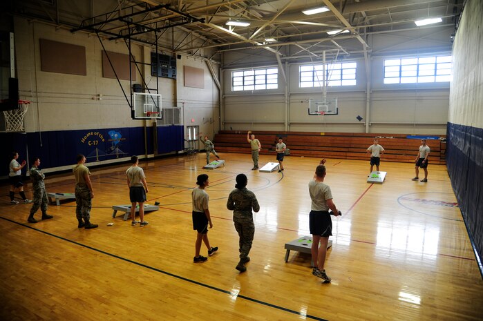 Airmen compete in a game of cornhole during the Dorm Challenge April 12, 2013, at the Fitness Center at Joint Base Charleston - Air Base, S.C. The quarterly dorm competition is a Wing initiative intended to encourage and incorporate all aspects of Comprehensive Airman Fitness, while encouraging resident interaction and camaraderie. The Dorm Challenge consisted of push-ups, sit-ups, cornhole and a game of dodgeball. (U.S. Air Force photo/Staff Sgt. Rasheen Douglas)