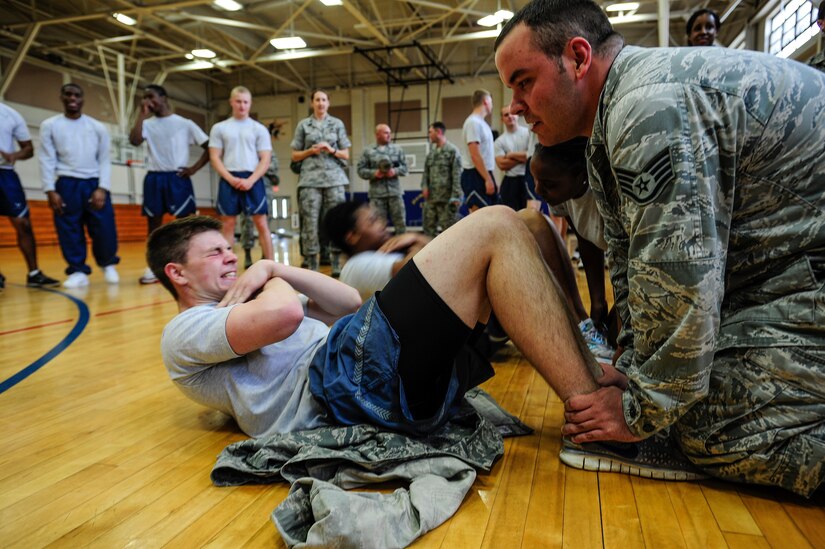 Airman 1st Class John Snyder,437th Maintenance Squadron crew chief, uses all his might to squeeze out extra sit-ups during the Dorm Challenge April 12, 2013, at the Fitness Center at Joint Base Charleston - Air Base, S.C. The quarterly Dorm Competition is a Wing initiative intended to encourage and incorporate all aspects of Comprehensive Airman Fitness, while encouraging resident interaction and camaraderie. The Dorm Challenge consisted of push-ups, sit-ups, cornhole and a game of dodgeball. (U.S. Air Force photo/Staff Sgt. Rasheen Douglas)