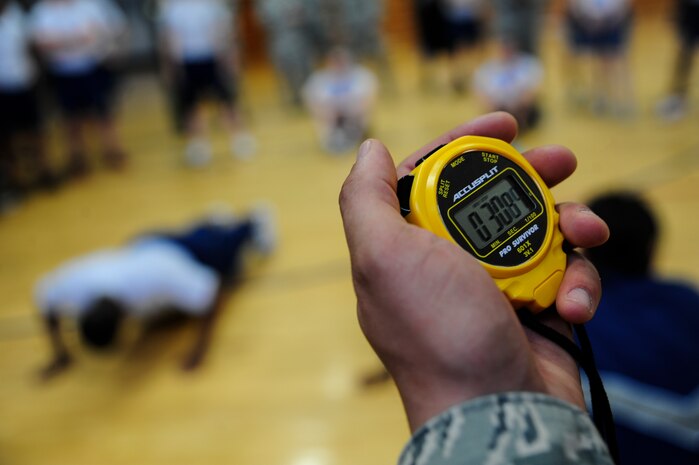 Time ticks away as Airmen squeeze out as many push-ups as they can before time is up during the Dorm Challenge April 12, 2013, at the Fitness Center at Joint Base Charleston - Air Base, S.C. The quarterly dorm competition is a Wing initiative intended to encourage and incorporate all aspects of Comprehensive Airman Fitness, while encouraging resident interaction and camaraderie. The Dorm Challenge consisted of push-ups, sit-ups, cornhole and dodgeball. (U.S. Air Force photo/Staff Sgt. Rasheen Douglas)