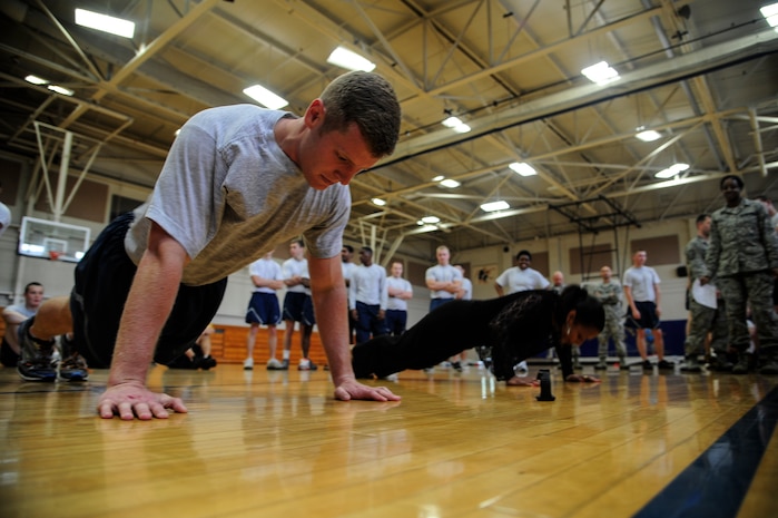 Senior Airman Matt Knopf, 628th Medical Group health services management technician, competes against Barbara Davis, 628th MDG budget analyst, to do as many push-ups as possible during the Dorm Challenge April 12, 2013, at the Fitness Center at Joint Base Charleston - Air Base, S.C. The quarterly dorm competition is a Wing initiative intended to encourage and incorporate all aspects of Comprehensive Airman Fitness, while encouraging resident interaction and camaraderie. The Dorm Challenge consisted of push-ups, sit-ups, cornhole and dodgeball. (U.S. Air Force photo/Staff Sgt. Rasheen Douglas)