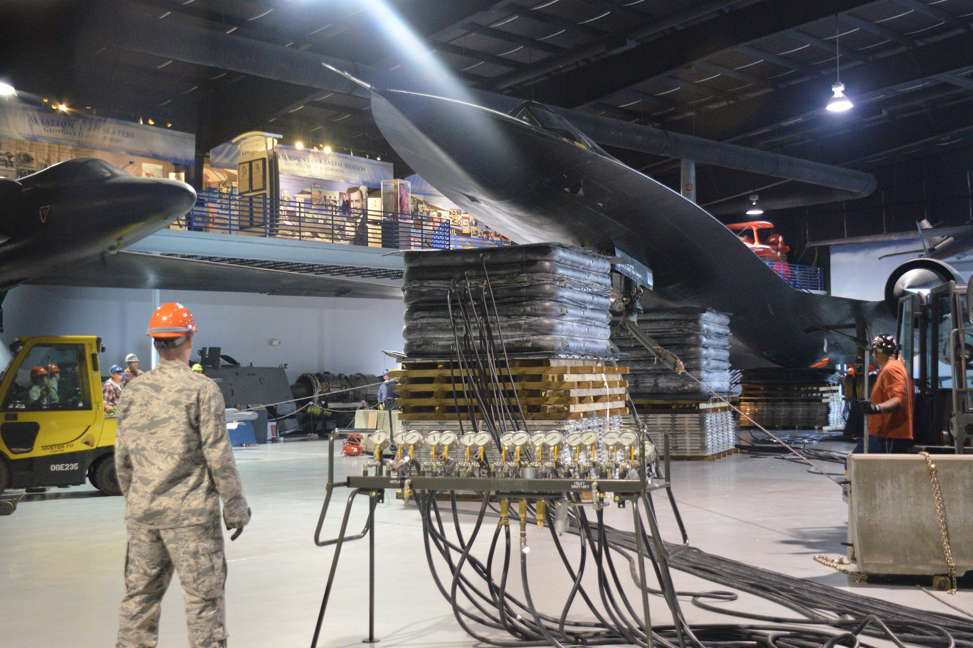 A team comprised of 402nd AMXG, 116th ACW and 461st ACW personnel known as the Crash, Disabled, Damage and Recovery Team, keep a close eye on the lifting of the SR-71 onto three stands giving the aircraft a takeoff profile at the Museum of Aviation at Robins Air Force Base. (U.S. Air Force photo by Edward Aspera/Released)