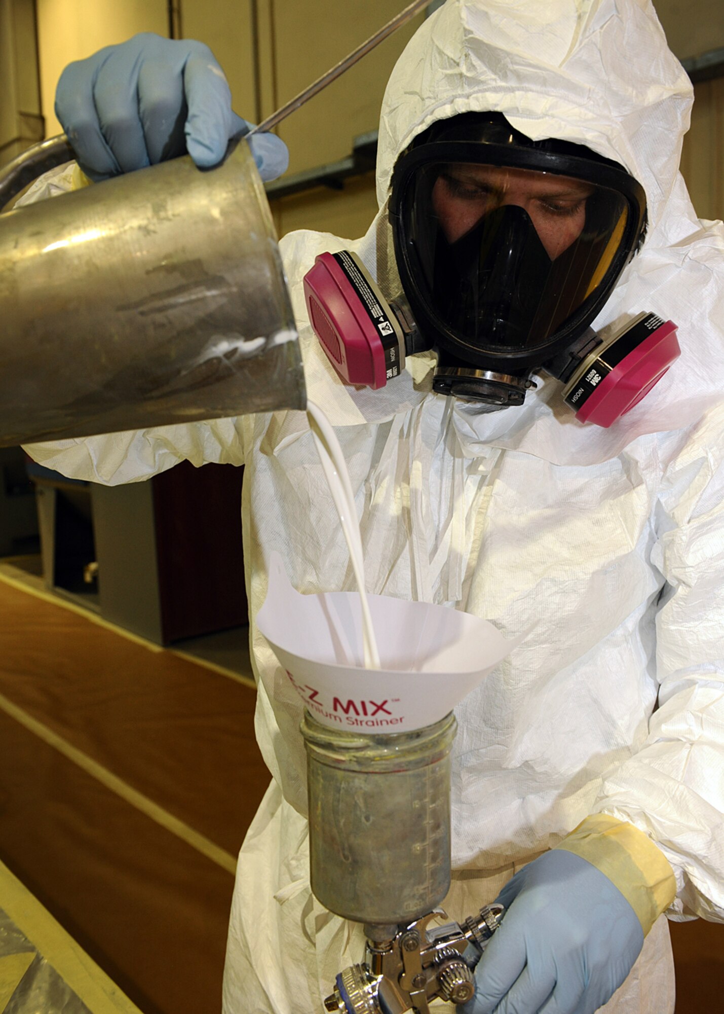SPANGDAHLEM AIR BASE, Germany – Nick Anderson, 52nd Equipment Maintenance Squadron Fabrication Flight Corrosion Control Element technician from Logan, Utah, pours gloss white paint into a paint gun April 16, 2013. The paint mixture is a specific measure between the paint itself and a catalyst, which helps the paint chemically cure. The chemical produces a toughened paint mixture for the equipment, which is the Air Force’s way of cutting costs from less frequent repairs. (U.S. Air Force photo by Staff Sgt. Daryl Knee/Released)