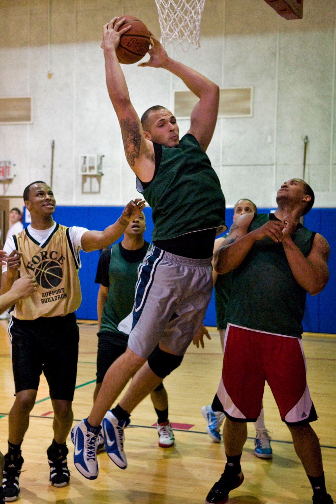 GRISSOM AIR RESERVE BASE, Ind. -- Michael Rivera, 434 Security Forces Squadron team member,   clinches the ball as fellow team member Clarence Ayers and Brandon Prince, 434th Force Support Squadron, watch during an annual basketball tournament here April 13. The Cops slam dunked Force Support in a game ending score 29-20. (U.S. Air Force graphic/Senior Airman Jami K. Lancette) 