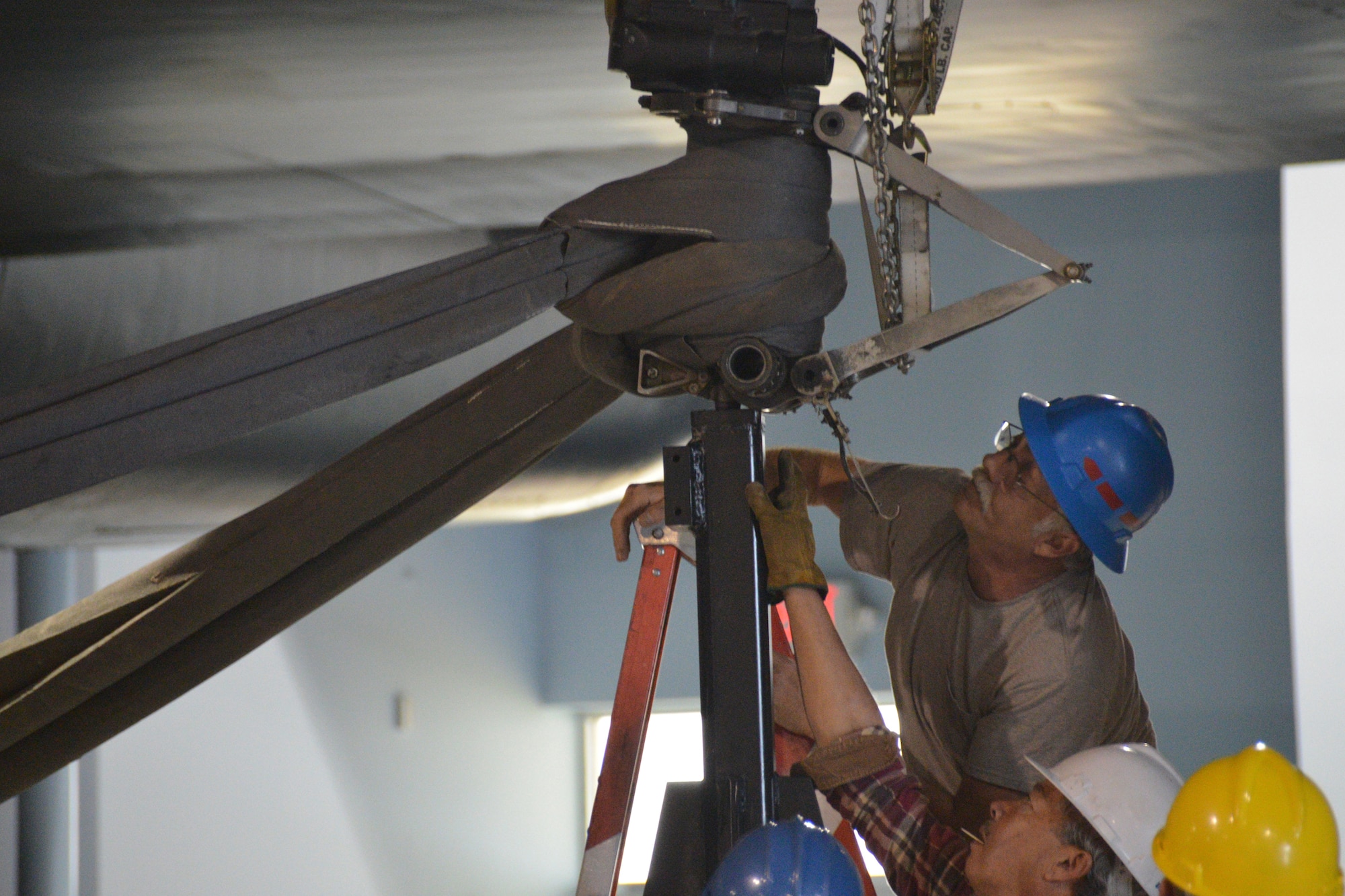 Doug Monahan (blue helmet) and Paul Kalani (white helmet) inspect the fitting of the nose wheel stand mount for proper alignment during the lifting of the SR-71 onto three lift stands into a takeoff profile at the Museum of Aviation at Robins Air Force Base. The lift was conducted by Crash, Disabled, Damage and Recovery Team personnel from the 402nd AMXG, 116th ACW and 461st ACW. (U.S. Air Force photo by Edward Aspera/Released)
