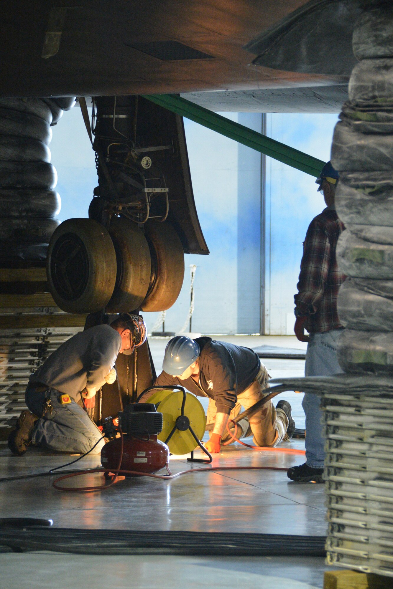 Tony Faircloth (left) and Erwin Ross (right) install the mounting bolts for the rear landing gear stand mount, during the lifting of the SR-71 onto three lift stands into a takeoff profile at the Museum of Aviation at Robins Air Force Base. The lift was conducted by Crash, Disabled, Damage and Recovery Team personnel from 402nd AMXG, 116th ACW and 461st ACW. (U.S. Air Force photo by Edward Aspera/Released)