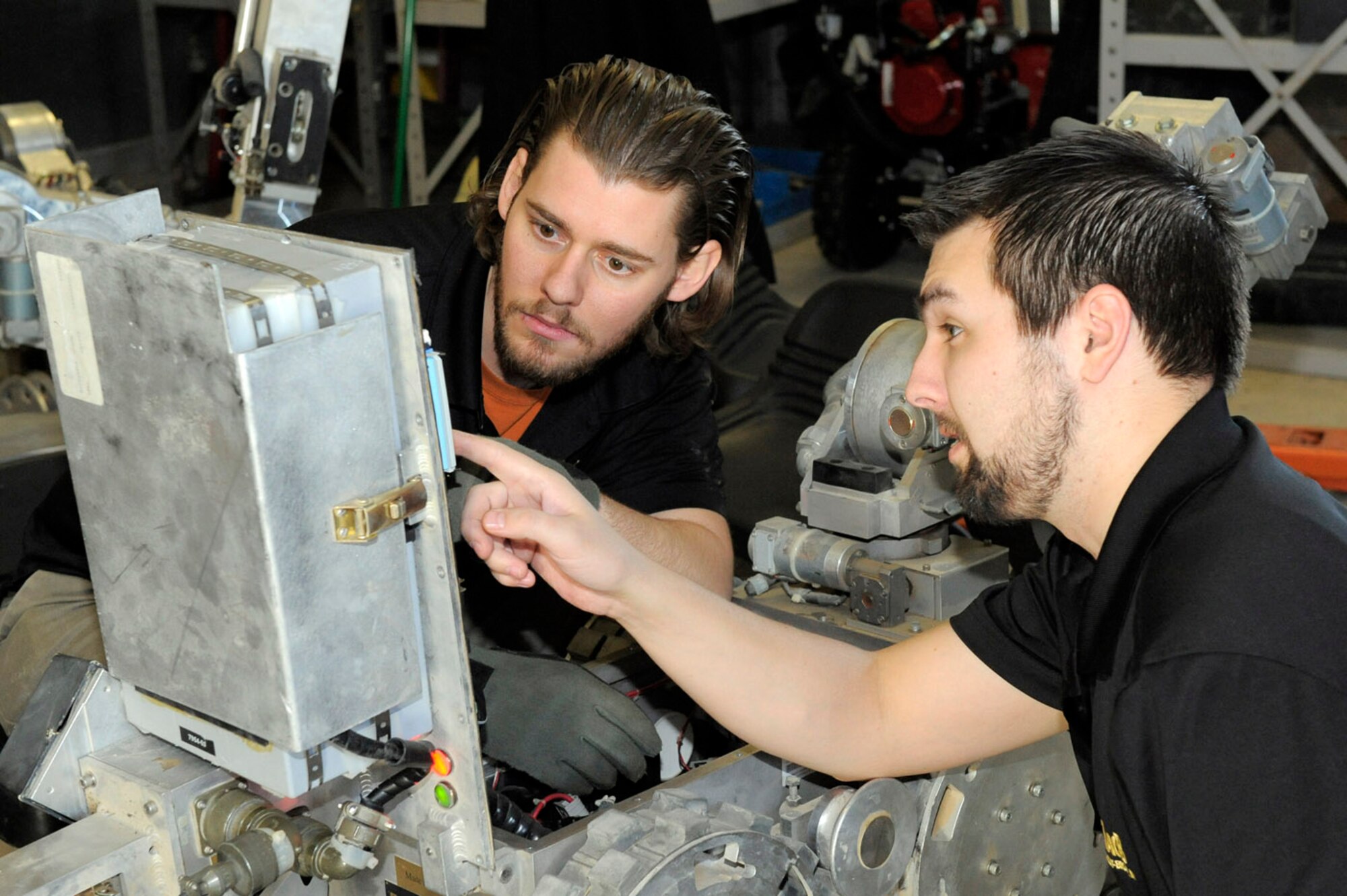 HILL AIR FORCE BASE, Utah -- From left, Michael Brettelle and Justin Bavery trouble shoot circuits on an EOD robot at the EOD Equipment Management Facility here. The EMF serves as a clearinghouse for EOD tools and equipment being shipped back from deployed locations throughout the world. At the EMF, a specialized team inspects, cleans and repairs the equipment before it is redistributed across the Air Force. (U.S. Air Force photo/Todd Cromar)