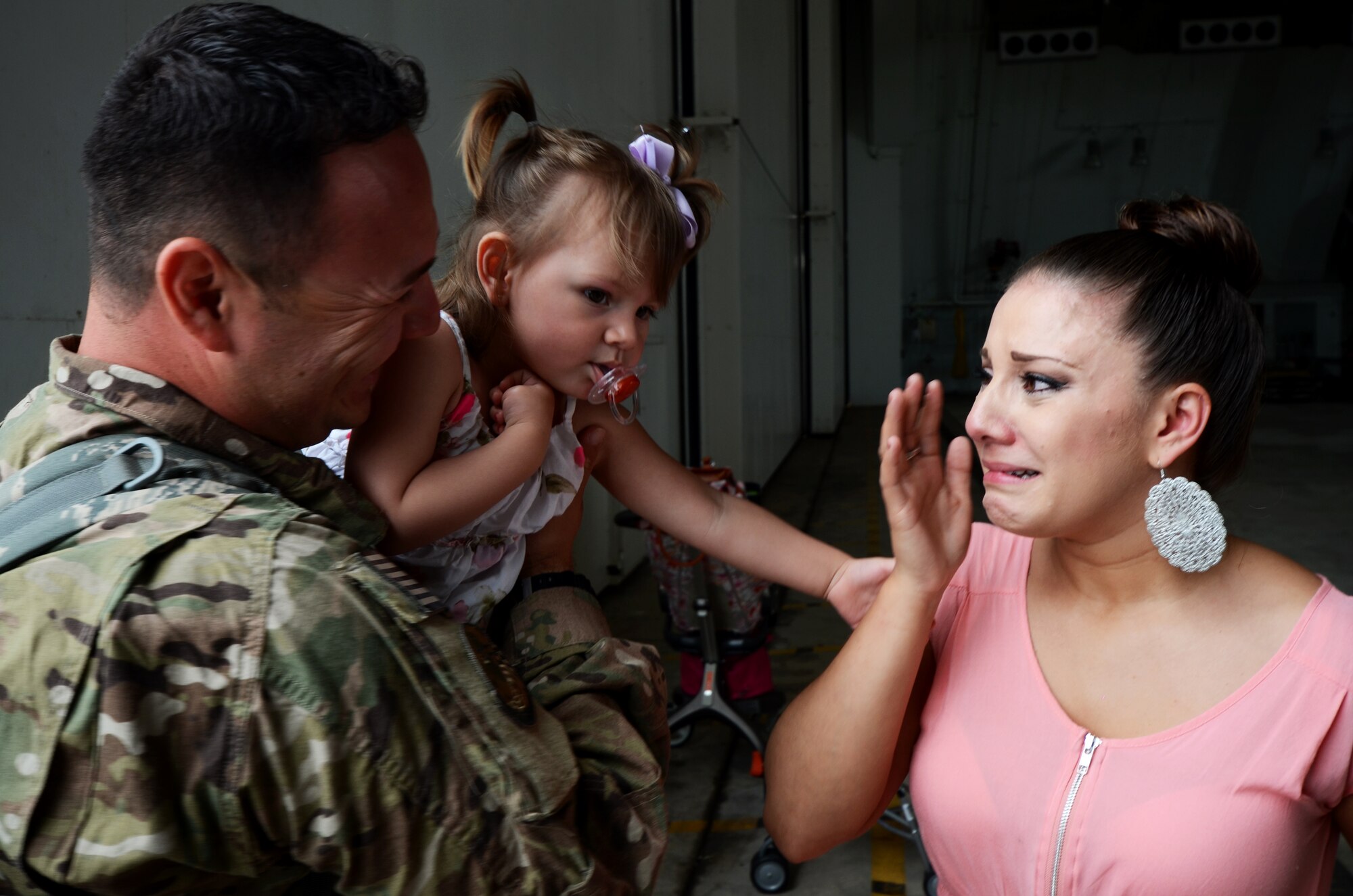 ANDERSEN AIR FORCE BASE, Guam — Staff Sgt. Jonathan Avila, 554th RED HORSE Squadron utilities technician, greets his wife and daughter during a homecoming in Hangar 1 on Andersen Air Force Base, Guam, April 16, 2013 The 554th RHS was deployed for seven months to Southwest Asia where they supported construction projects for eight different sites in and around the region. (U.S. Air Force photo by Senior Airman Benjamin Wiseman/Released)