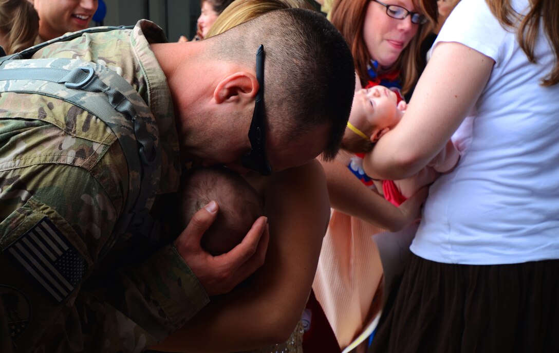 ANDERSEN AIR FORCE BASE, Guam — Staff Sgt. Andrew Zimmerman, 554th RED HORSE Squadron electrical unit technician, kisses his son during a homecoming in Hangar 1 on Andersen Air Force Base, Guam, April 16, 2013. The 554th RHS was deployed for seven months to Southwest Asia where they supported construction projects for eight different sites in and around the region. (U.S. Air Force photo by Senior Airman Benjamin Wiseman/Released)