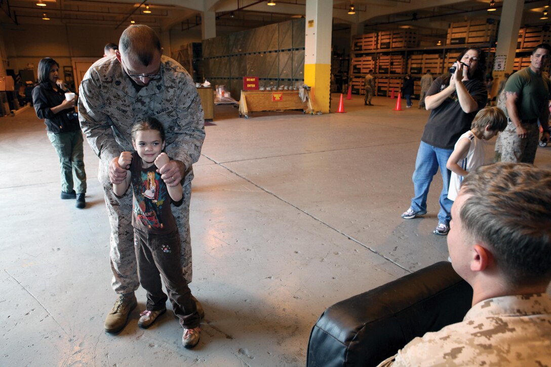 Staff Sgt. Austen P. Harms teaches his 5-year-old daughter Haleigh-Ann basic Marine Corps martial arts program techniques during a junior warrior day at Camp Kinser April 12. Throughout the day, children participated in many activities, including an obstacle course, martial arts and tricycle races. Harms is a motor transport maintenance chief with Combat Logistics Regiment 35, 3rd MLG, III MEF. 