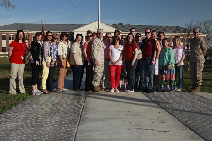 Col. Philip J. Zimmerman (center), commanding officer of Cherry Point, Sgt. Maj. Angela M. Maness (right), sargeant major of Cherry Point, and 19 Craven County leaders stand in front of the flag pole after morning colors April 11 during the Craven County Leadership tour.